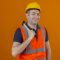 construction worker wearing vest and yellow safety helmet holding hammer with a smile on face isolated on orange background