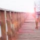 Asian man in hat with backpack travelling on bridge to the sea, Summer travel, Color filter with lens flare