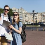 front-view-tourist-couple-holding-tablet