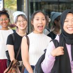 Group of happy multi-ethnic young women standing in a row. Selected focus.