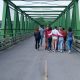 Group of young people crossing a bridge back to back and together