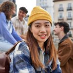 Joyful Chinese girl with friends in Madrid.