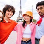 Group of young happy friends visiting Paris and Eiffel Tower, Trocadero area and Seine river - Multicultural group of tourists sightseeing the France capital city