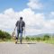 Young Man Traveler with backpack walking on the road. Summer vacations and Lifestyle hiking Advanture travel concept.