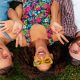 top view from above on colorful stylish happy young company of friends lying on grass in park, man and women having fun together, summer hipster fashion style, traveling smiling and positive