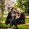 Young female tourists taking selfie with mobile photo on the bench in centre of Vienna, Austria